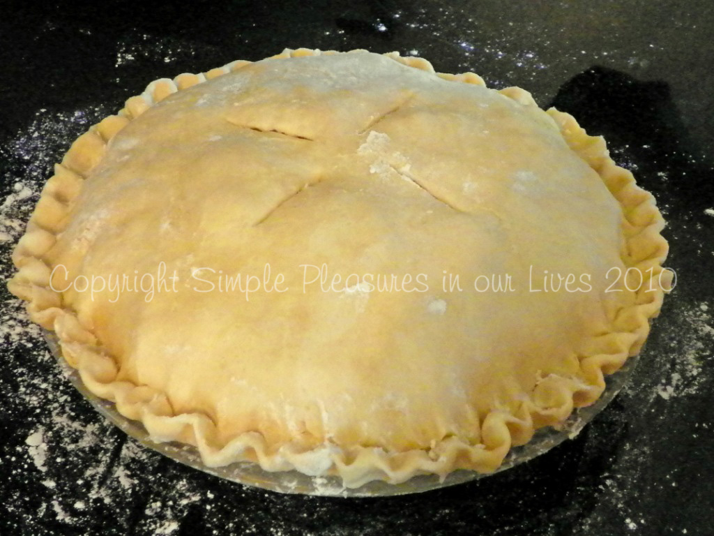 Top with the remaining dough, crimp, cut four 2-inch slits, and sprinkle with turbinado sugar